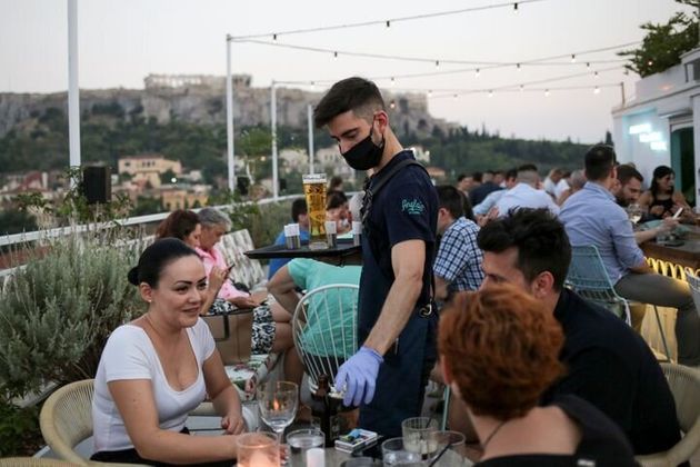 Un serveur dans un bar d’Athènes le 1er août. Depuis l’assouplissement du confinement, le nombre de cas...