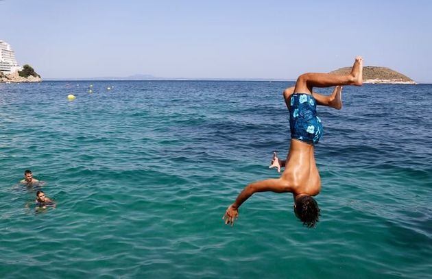 Un garçon plonge des falaises de la plage de Magaluf, à Majorque (Espagne), le 30 juillet. La région...