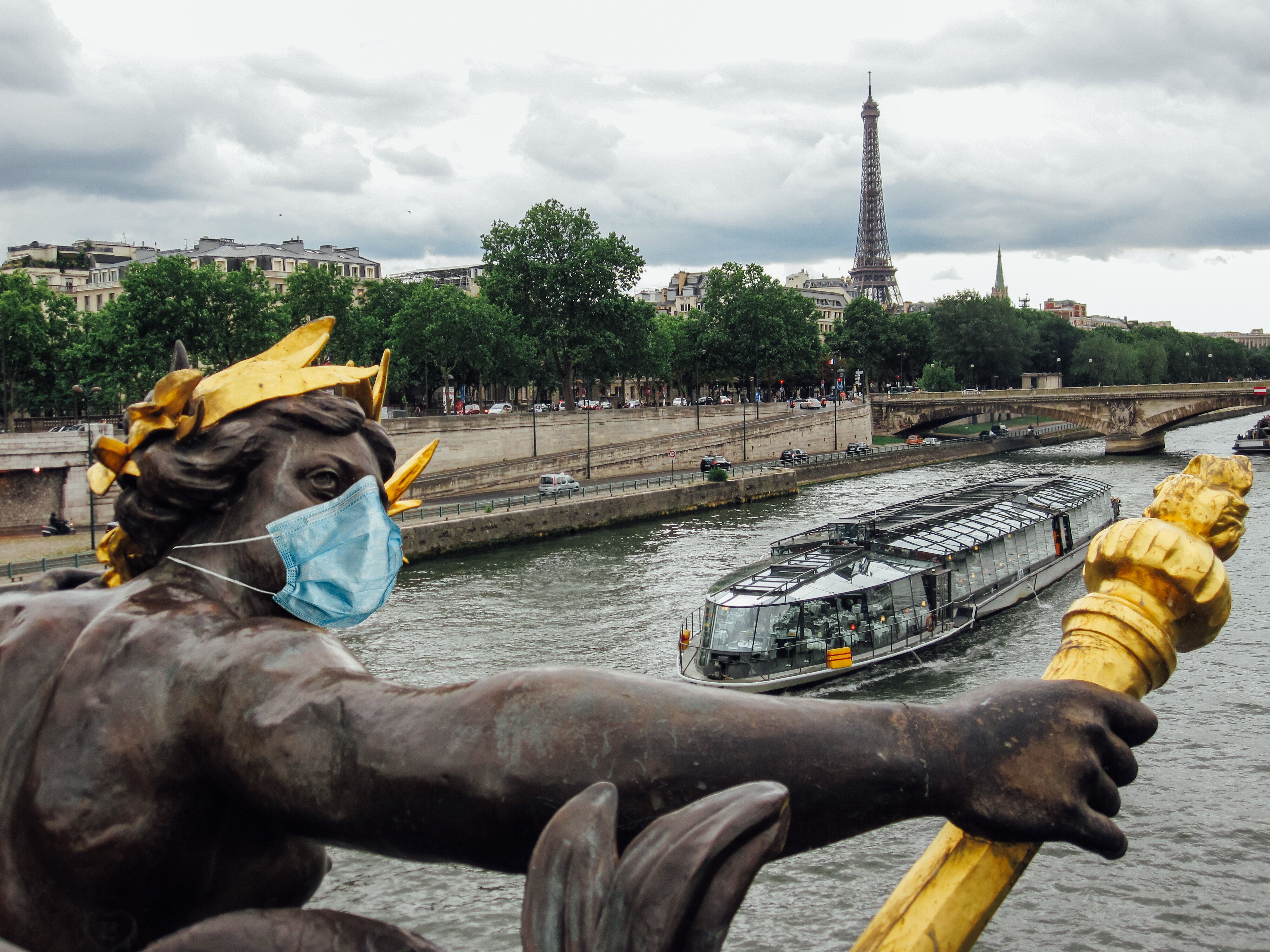 Statue at Alexander III bridge wearing a surgical face mask as a symbol of the Paris lockdown caused...