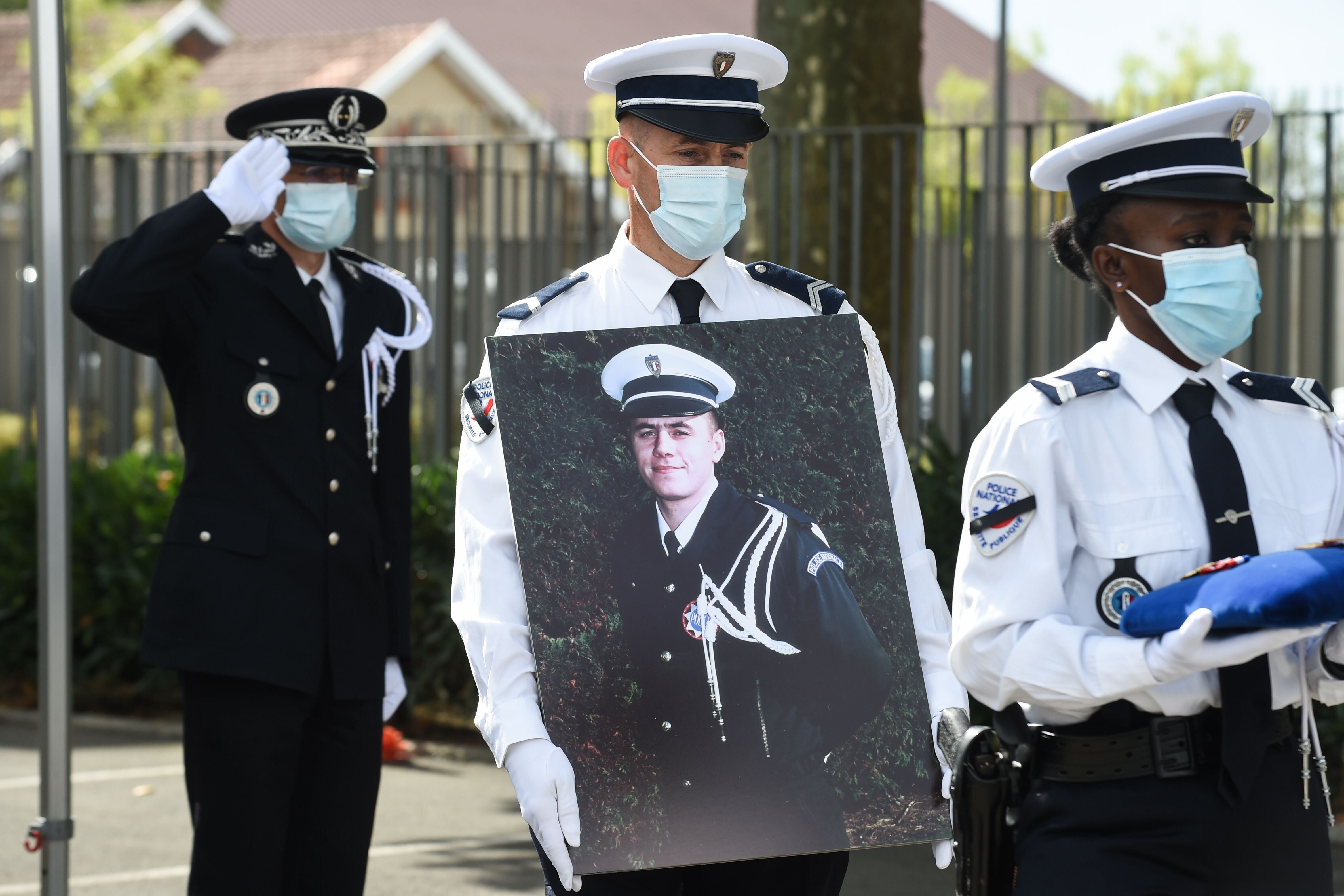 Un policier porte une photo d'Éric Monroy lors de la cérémonie d'hommage national...