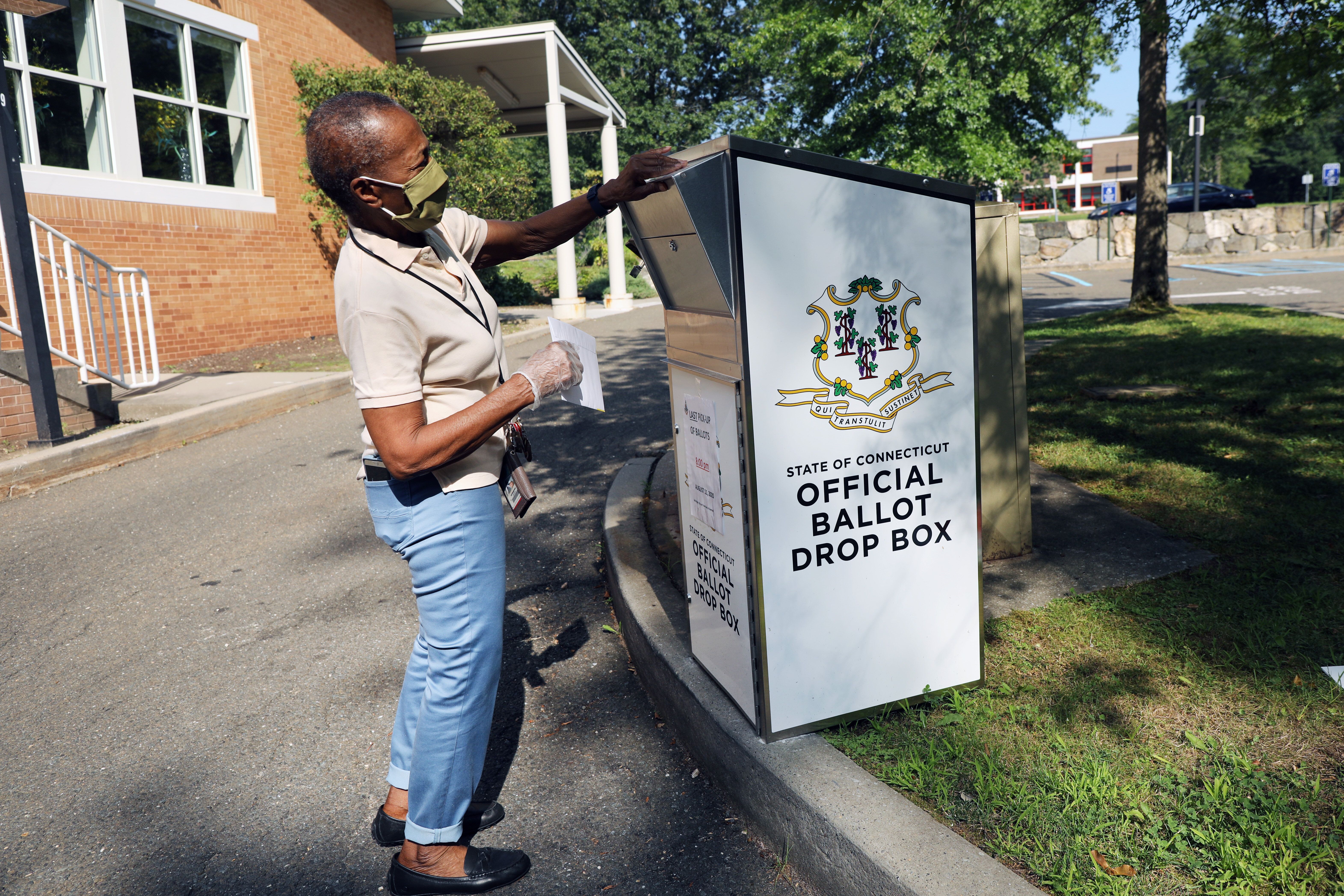 Une femme déposant son bulletin dans une boîte de vote à Stamford, dans le Connecticut,...