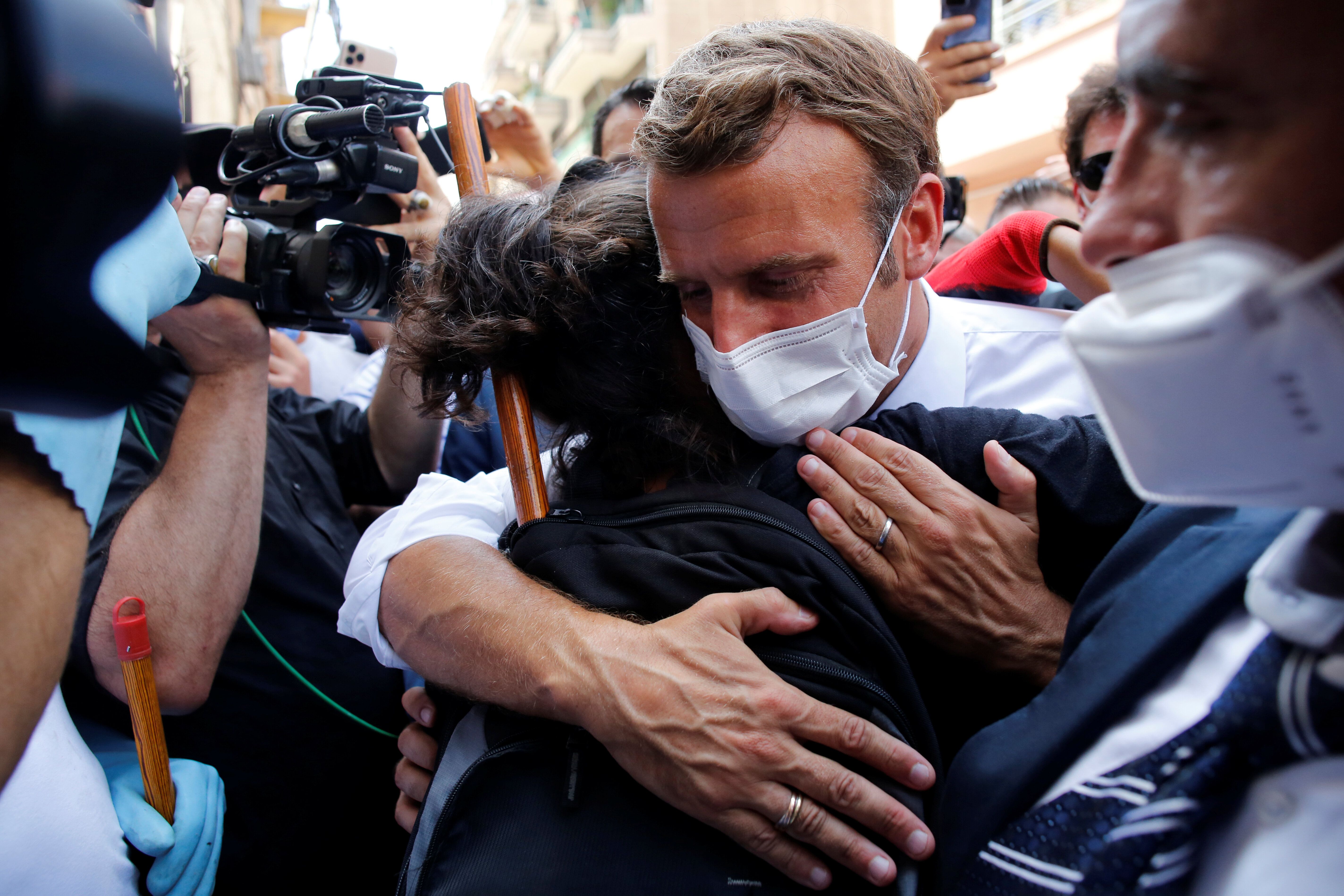 Le président Emmanuel Macron prend une habitante de Beyrouth dans ses bras alors qu'il visite...