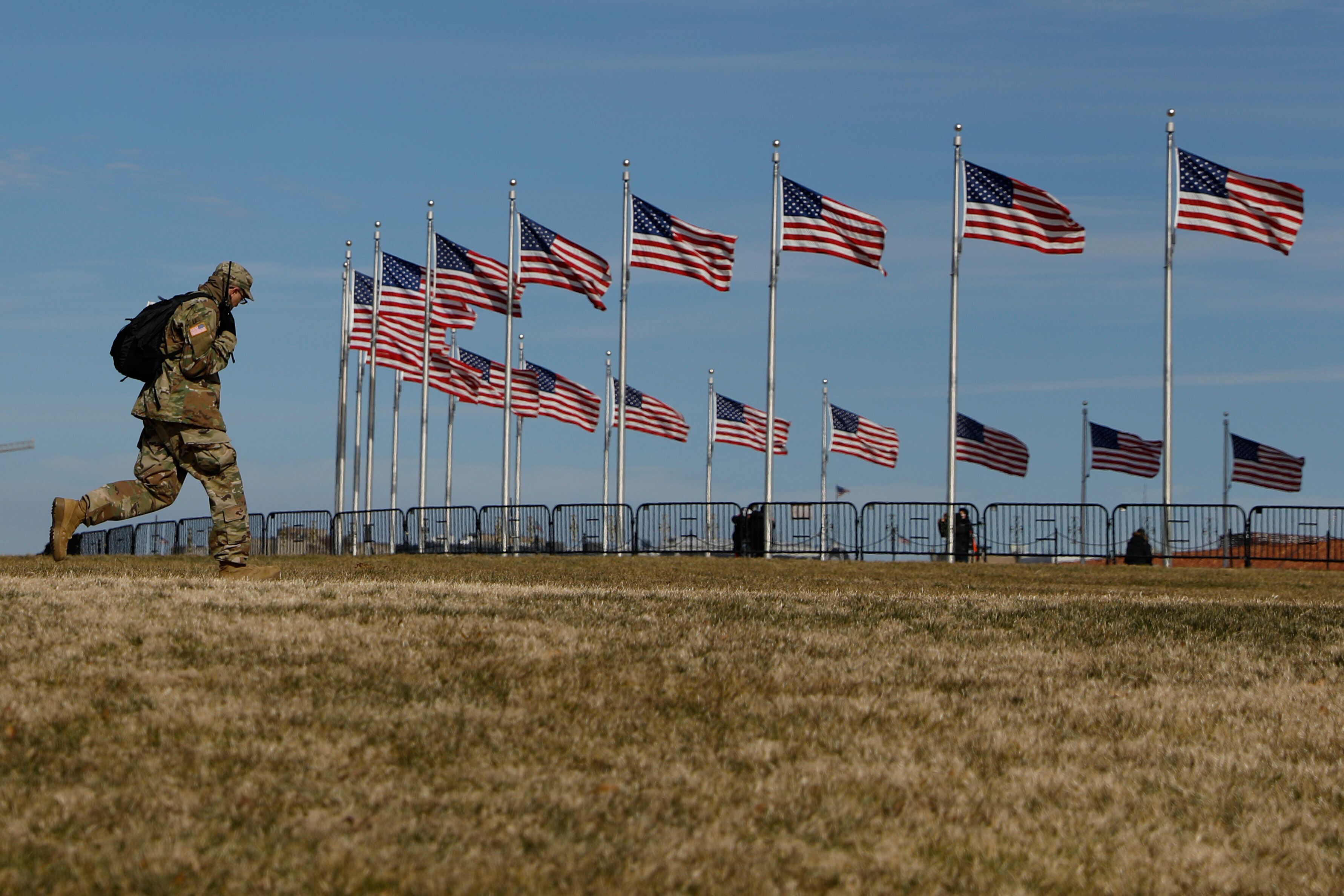 A National Guardsman walks past flags on the National Mall, four days after the inauguration of President...