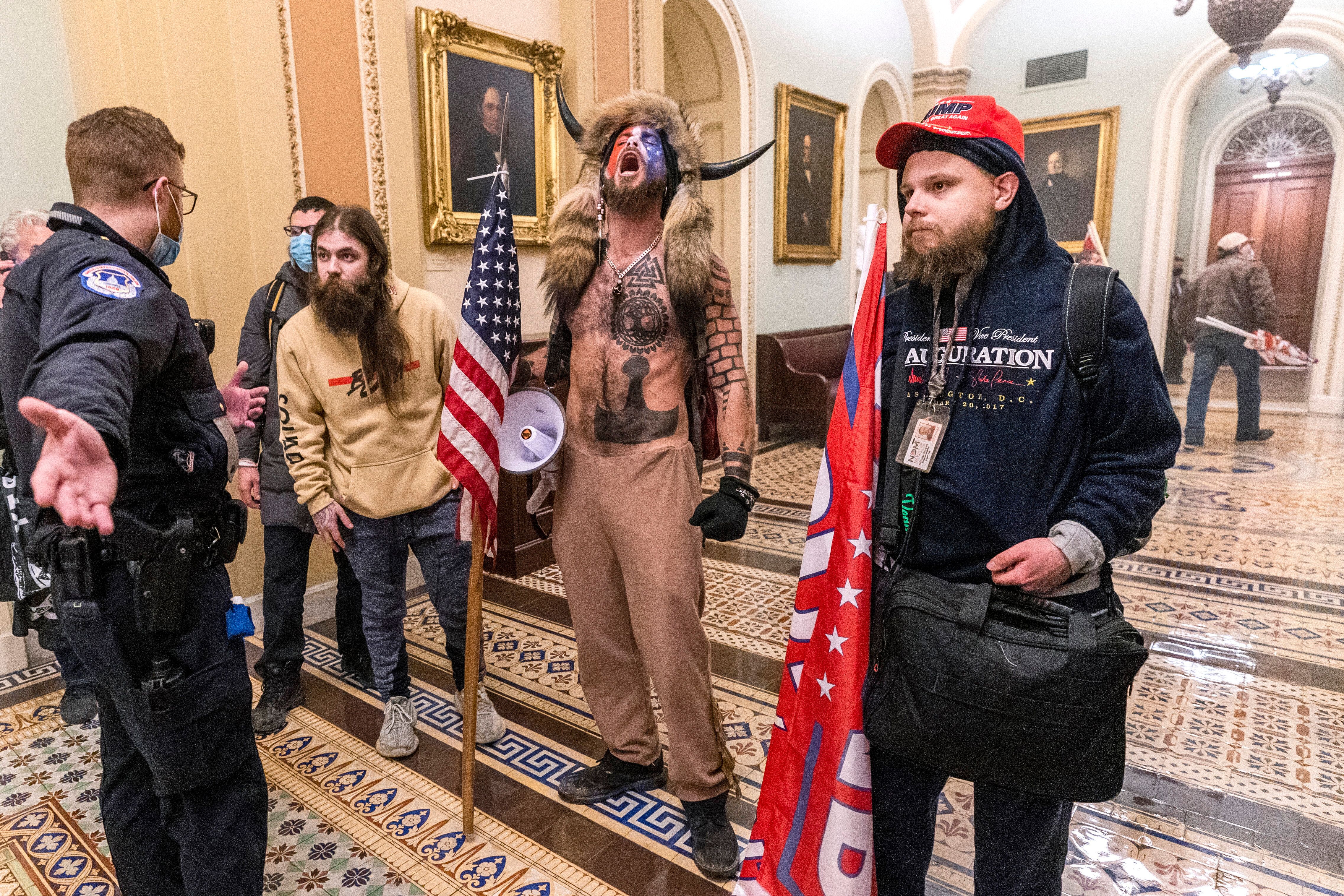 Supporters of President Donald Trump are confronted by Capitol Police officers outside the Senate Chamber...