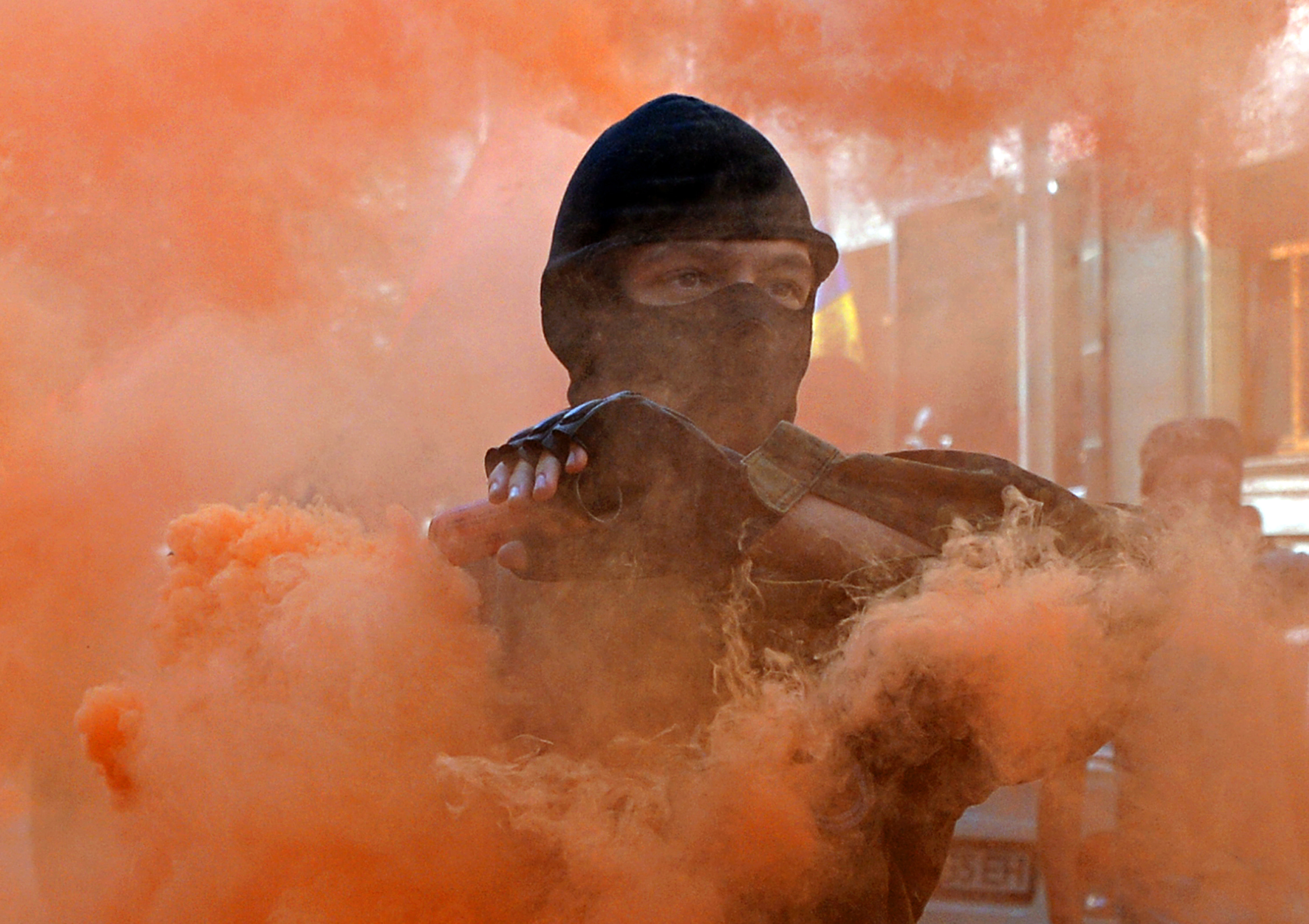 Un manifestant tient une bombe fumigène lors d’une manifestation à Kiev, en 2014. Photo : Genya Savilov/AFP via Getty Images