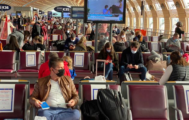 Passagers en salle d'attente occupant un siège sur deux à l'aéroport de Roissy,...