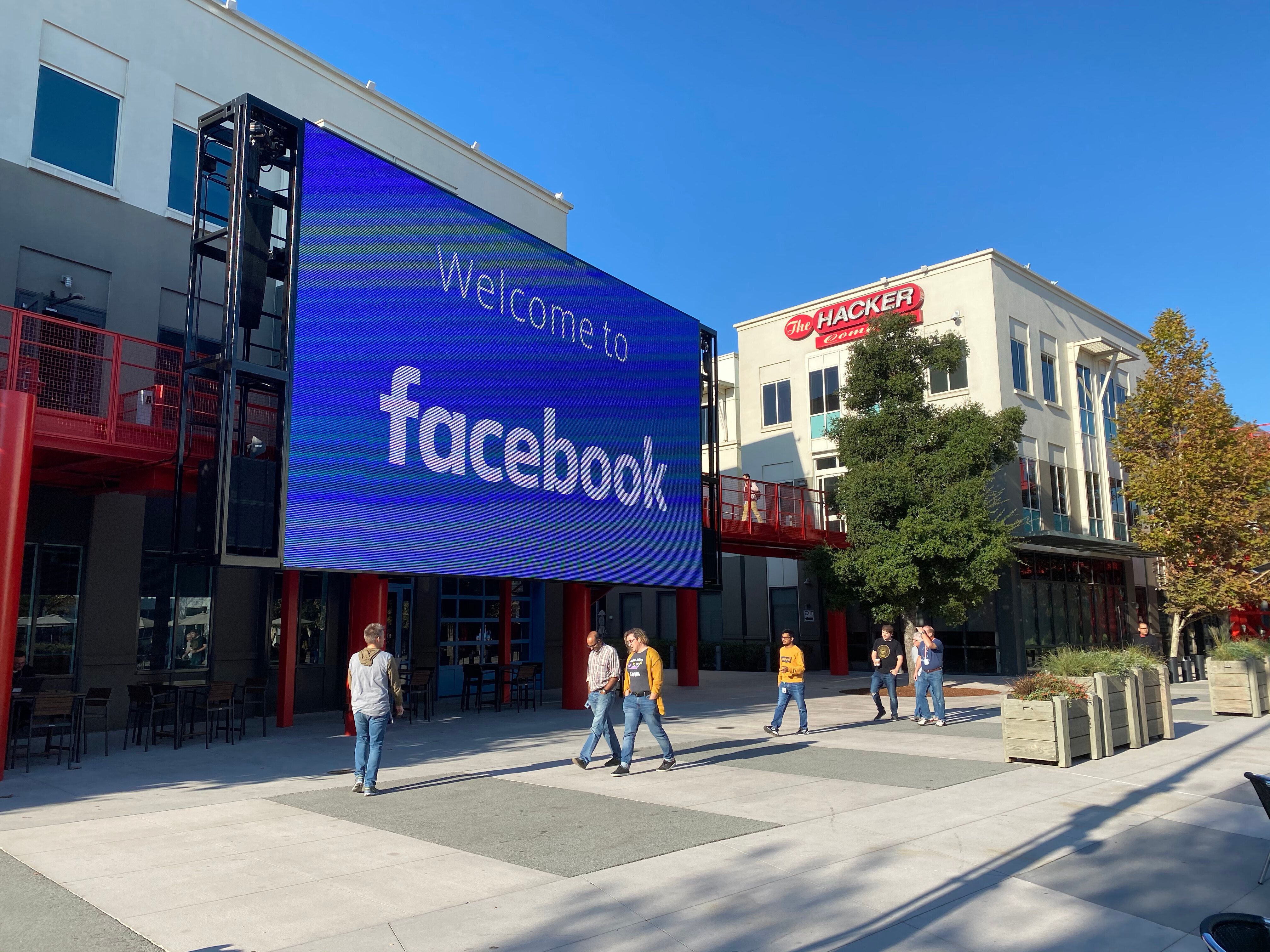 06 November 2019, US, Menlo Park: Employees of the Internet company Facebook walk through the courtyard...