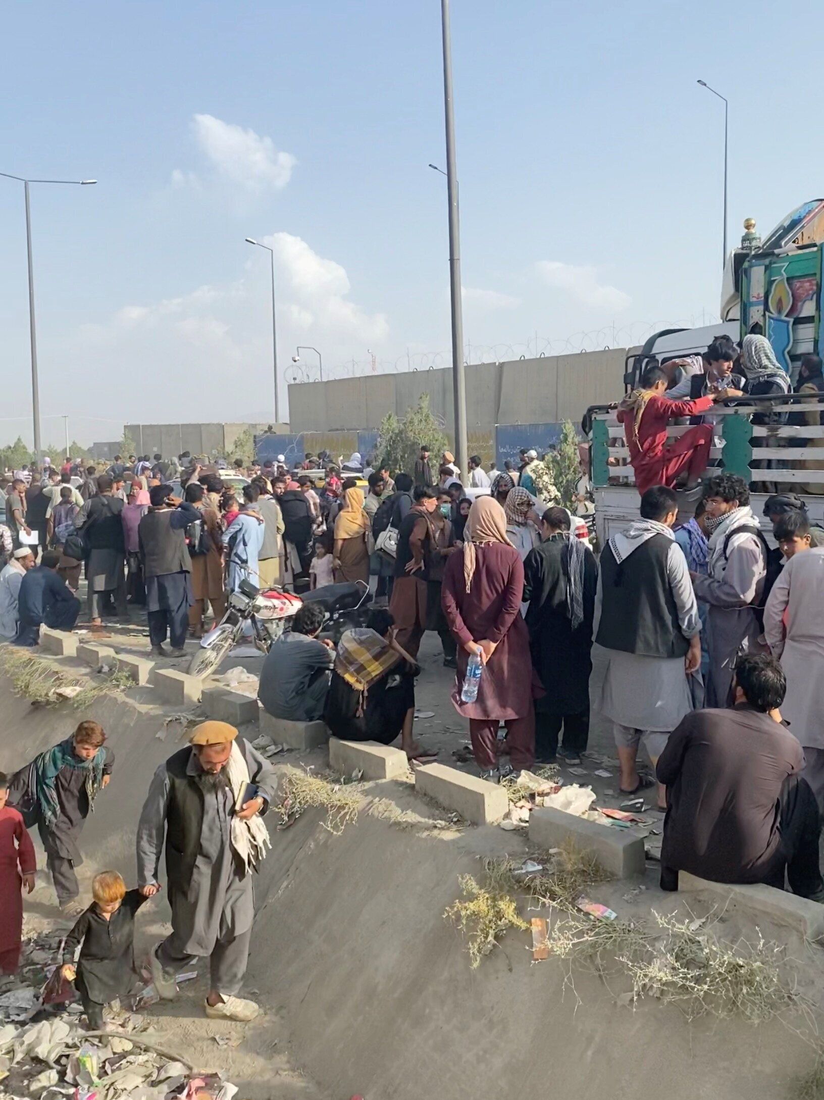 Des Afghans attendant devant l'aéroport de Kaboul, en Afghanistan, le 19 août