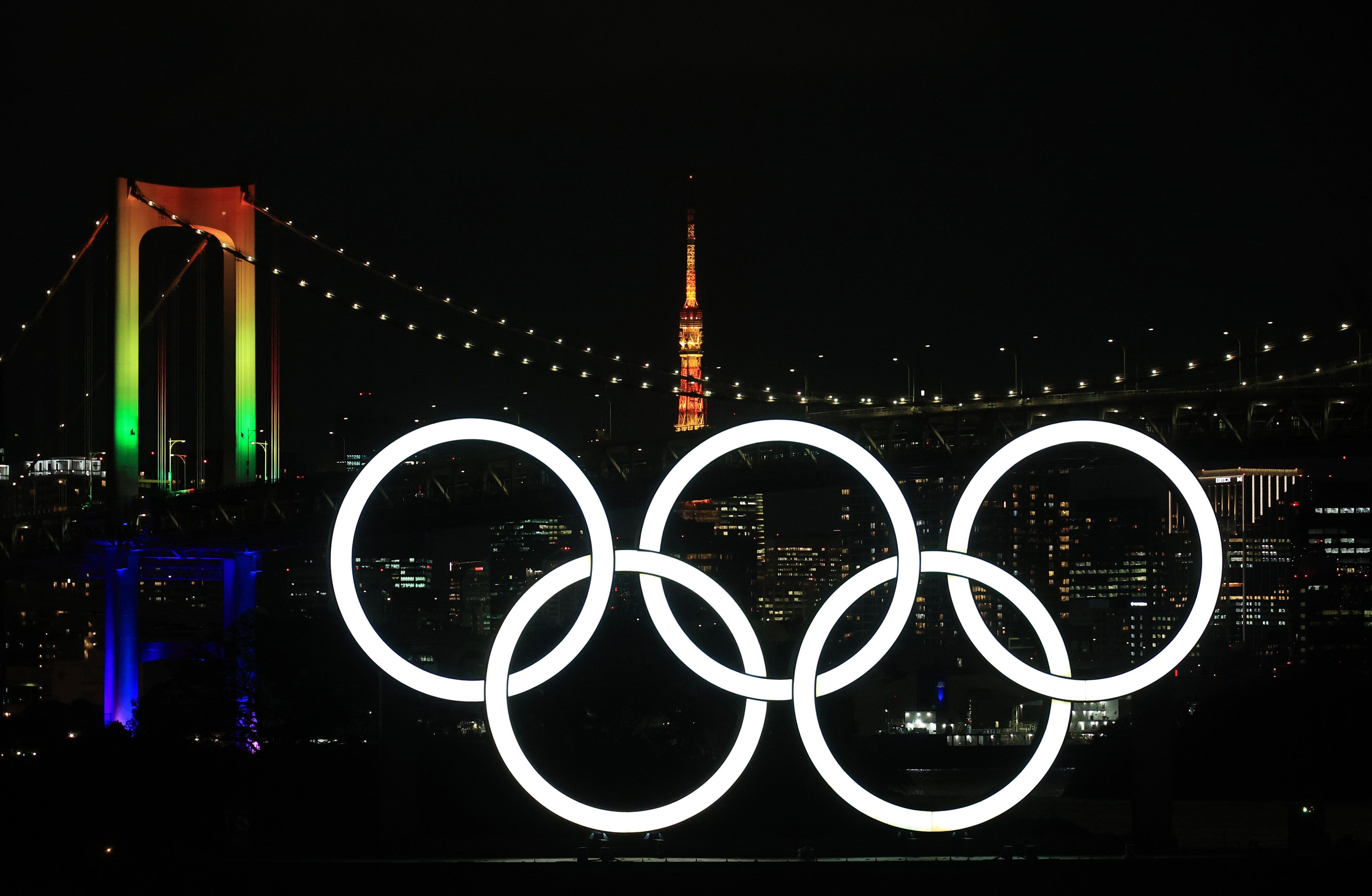 Les anneaux olympiques illuminés devant le Rainbow Bridge et la tour de Tokyo, le 1er décembre...