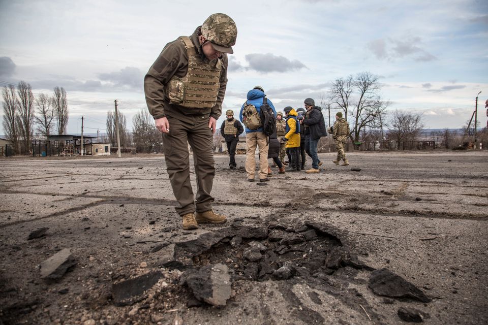 Un soldat ukrainien devant l'impact d'un obus dans le village de Novoluhanske, près de Louhansk...