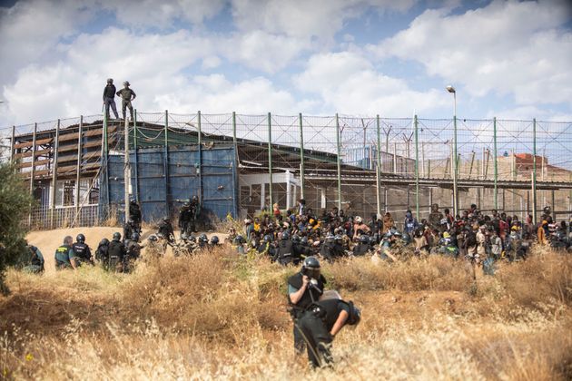 Des migrants arrivent sur le sol espagnol après avoir traversé les clôtures séparant...