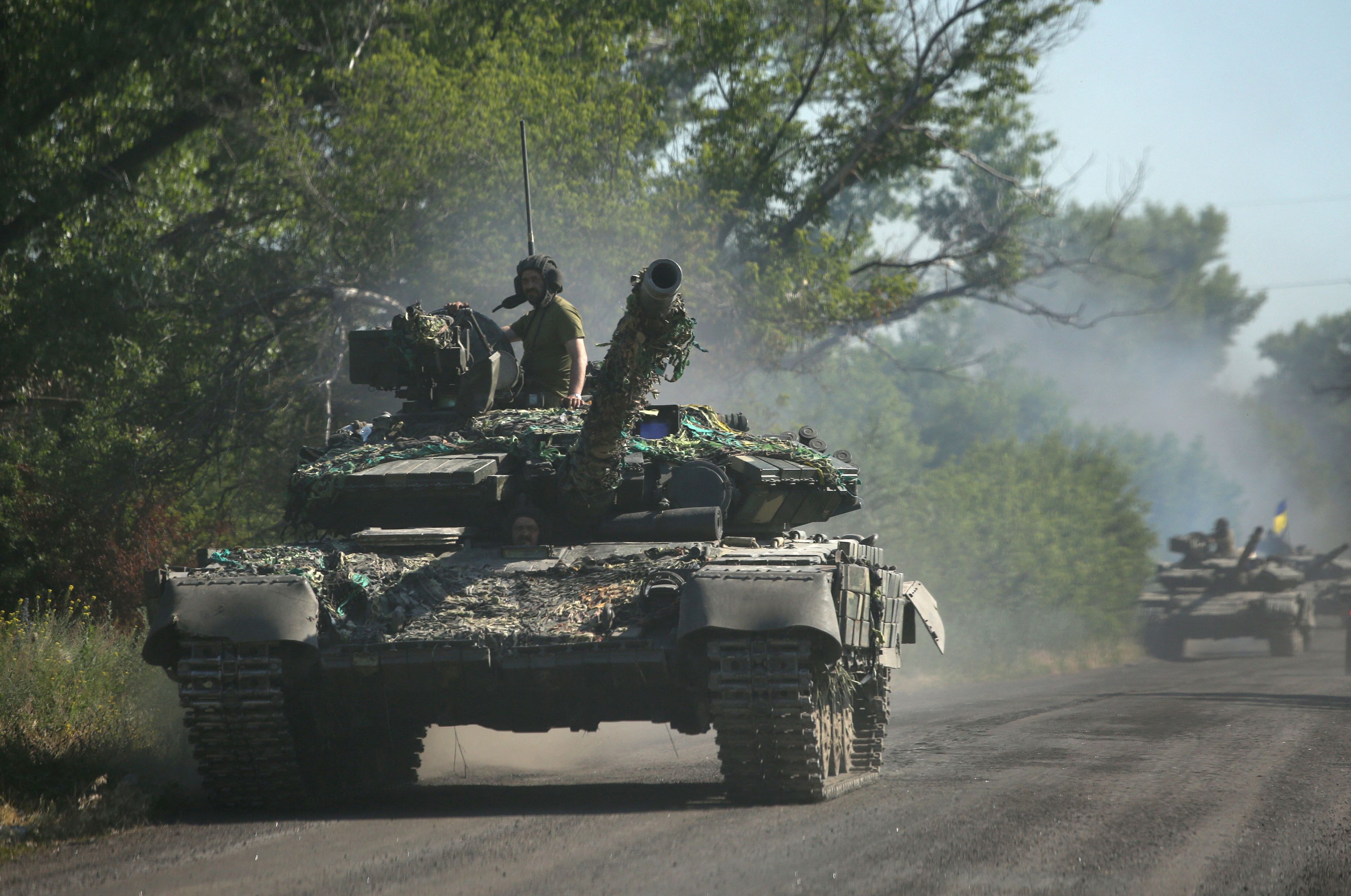 Les troupes ukrainiennes se retirent par chars sur une route du Donbass, alors que l'Ukraine affirme...